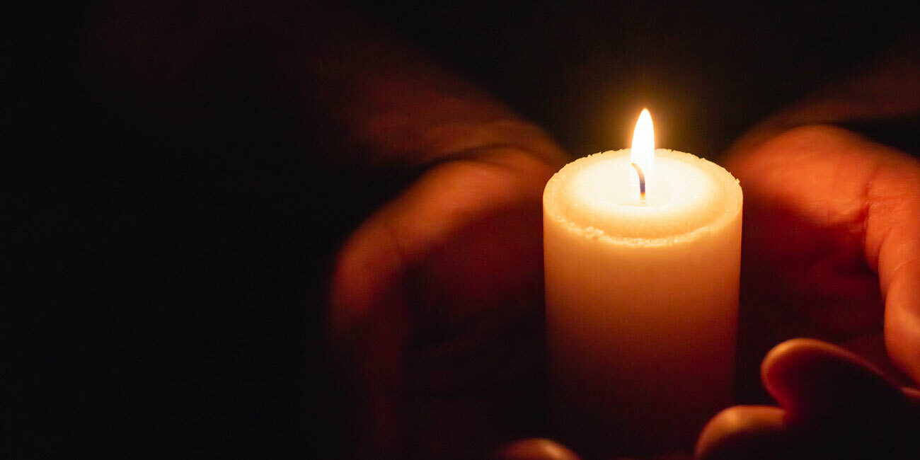 Hands holding candle Adobe Stock 460295100