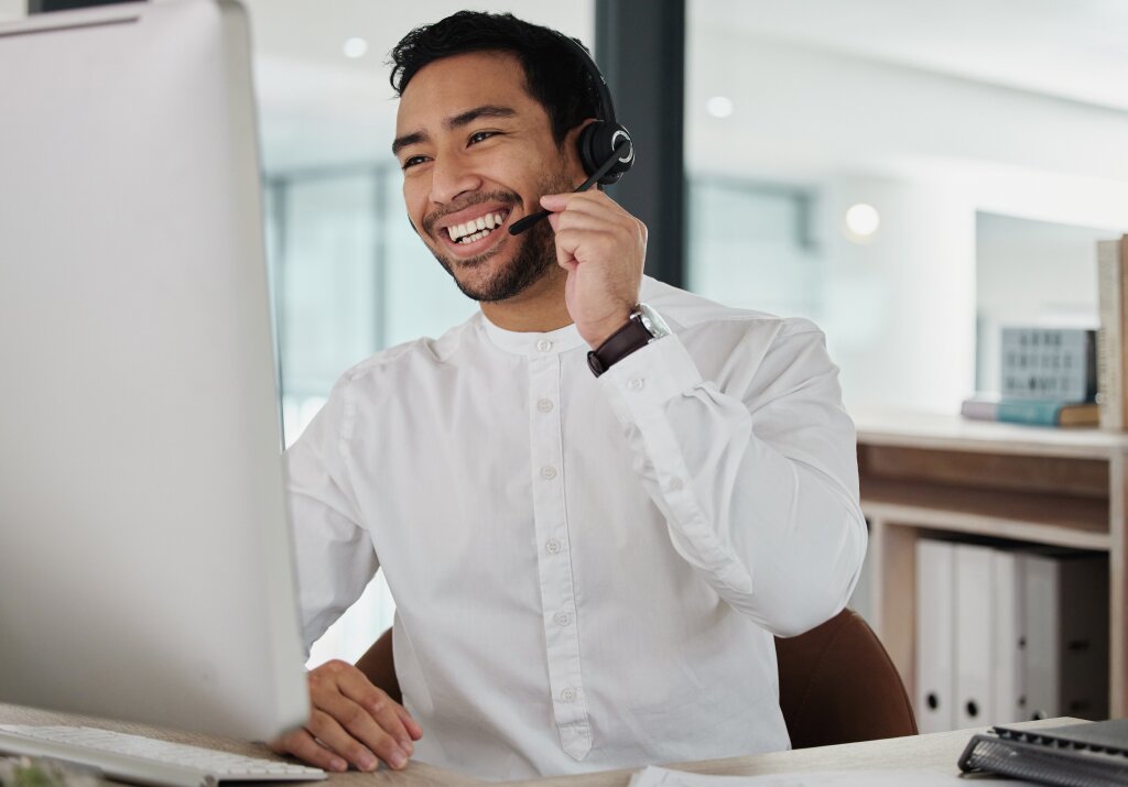 A call centre trainee demonstrates professional customer service and communication skills at his desktop workstation.