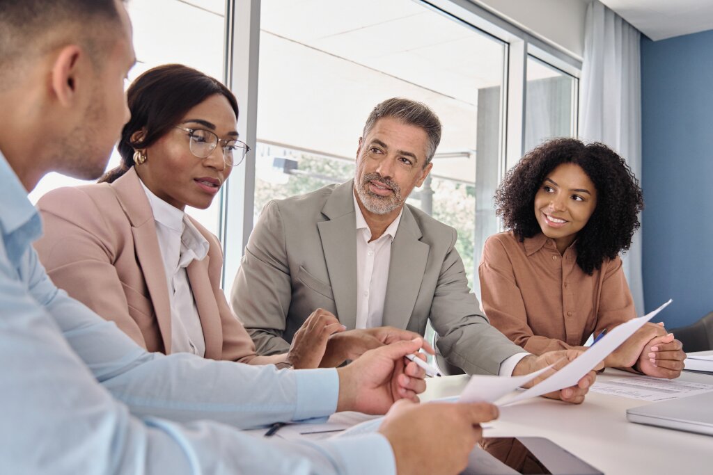 A professional team manager collaborates with her corporate department during a strategic staff meeting to review key operational performance reports.