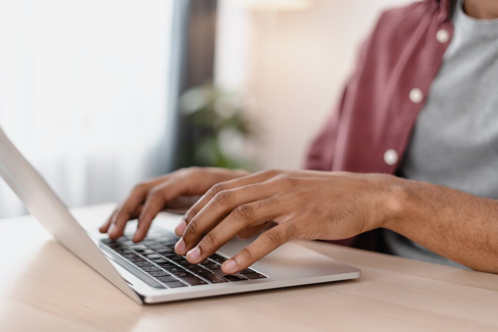 A student types on a laptop keyboard to complete an online course assignment or log into their RTO portal dashboard.