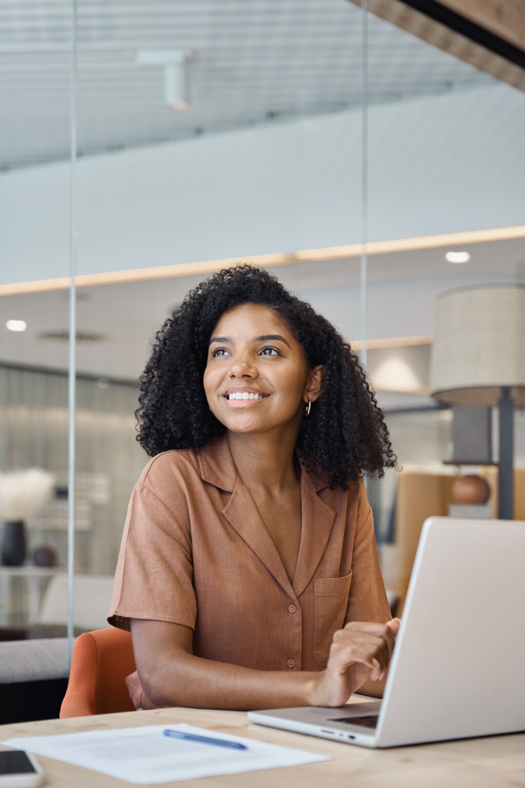 A smiling student feels inspired while planning her online vocational studies and future career pathways at her desk.