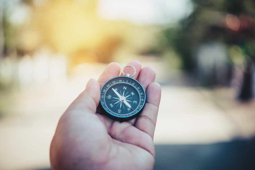 A jobseeker uses a compass metaphorically to represent strategic career planning and choosing a vocational trade path.