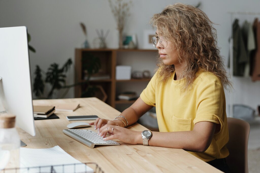 An adult student sits at a workspace with an open laptop, engaging in flexible study or online vocational training.
