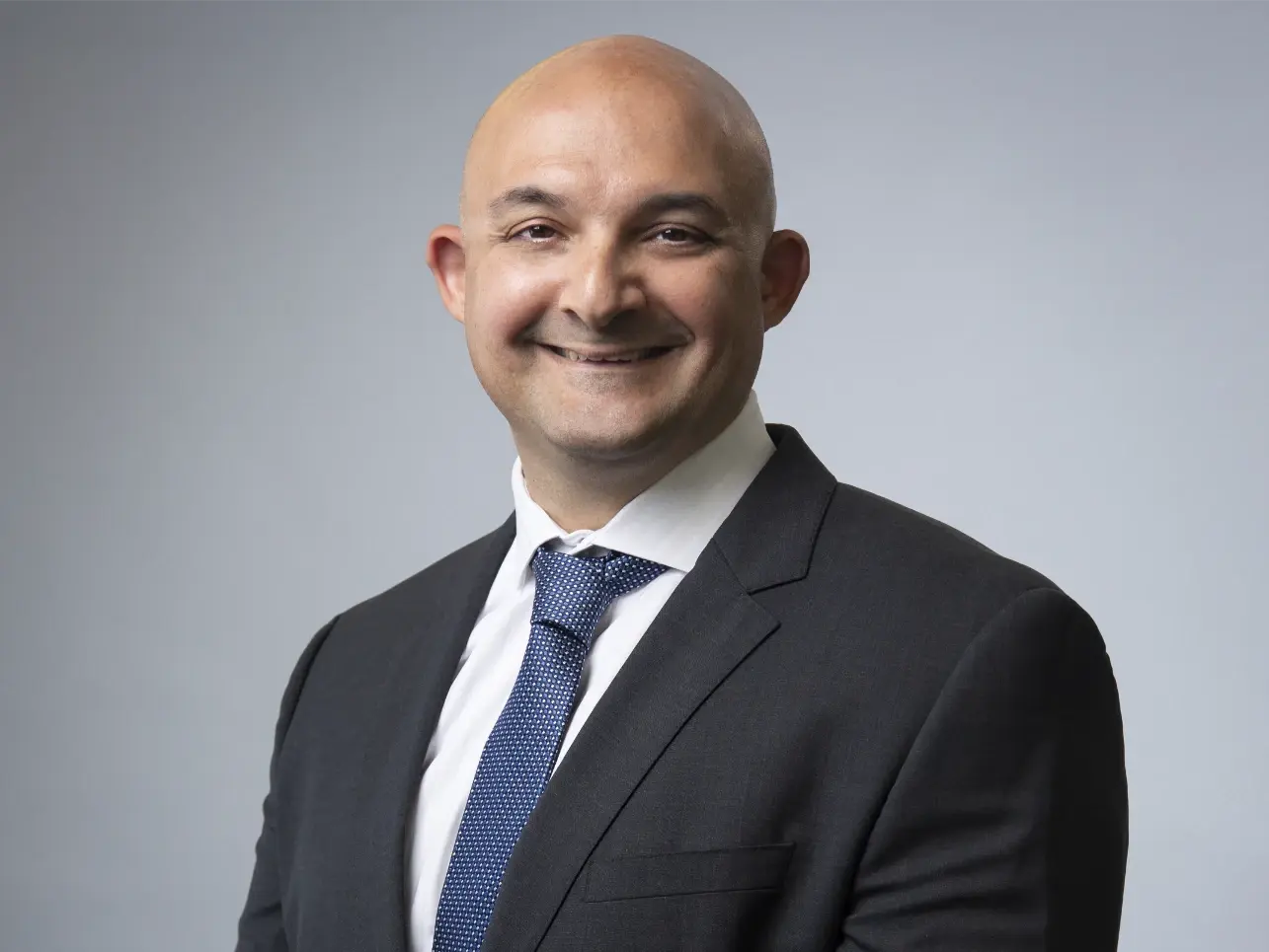 Dr. Ray Shah, smiling in professional attire.