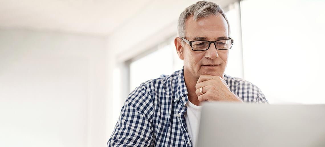 A manager sitting working on his laptop