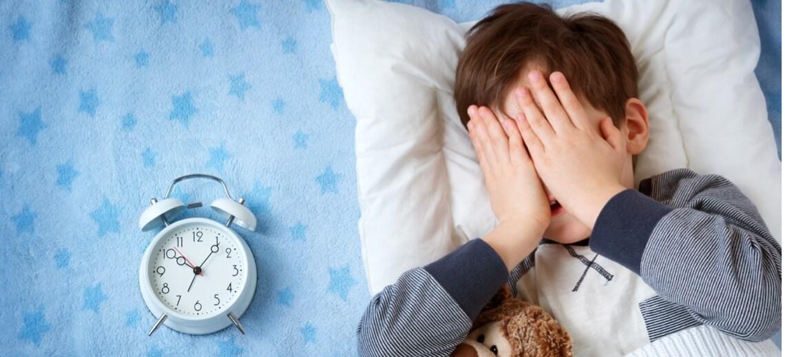 Child in bed, having difficulty sleeping.