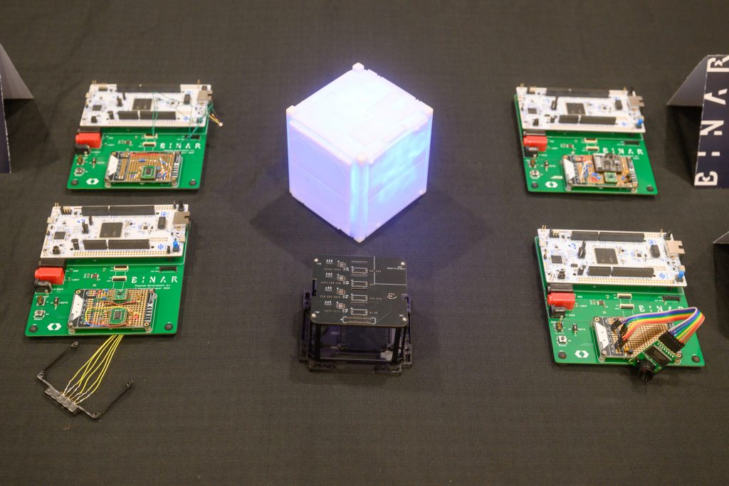The BinarX High School Student-Designed & Built Payloads for Binar-5 (mounted on green Binar Payload Development Kit boards for testing) next to the Binar-5 Payload Bay (bottom middle of photo)