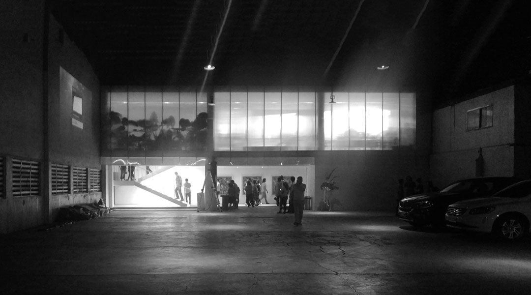 Silhouettes of gallery-goers and shadows of potted plants at the stairwell admit people into opening night of Silverlens inaugural show Translación