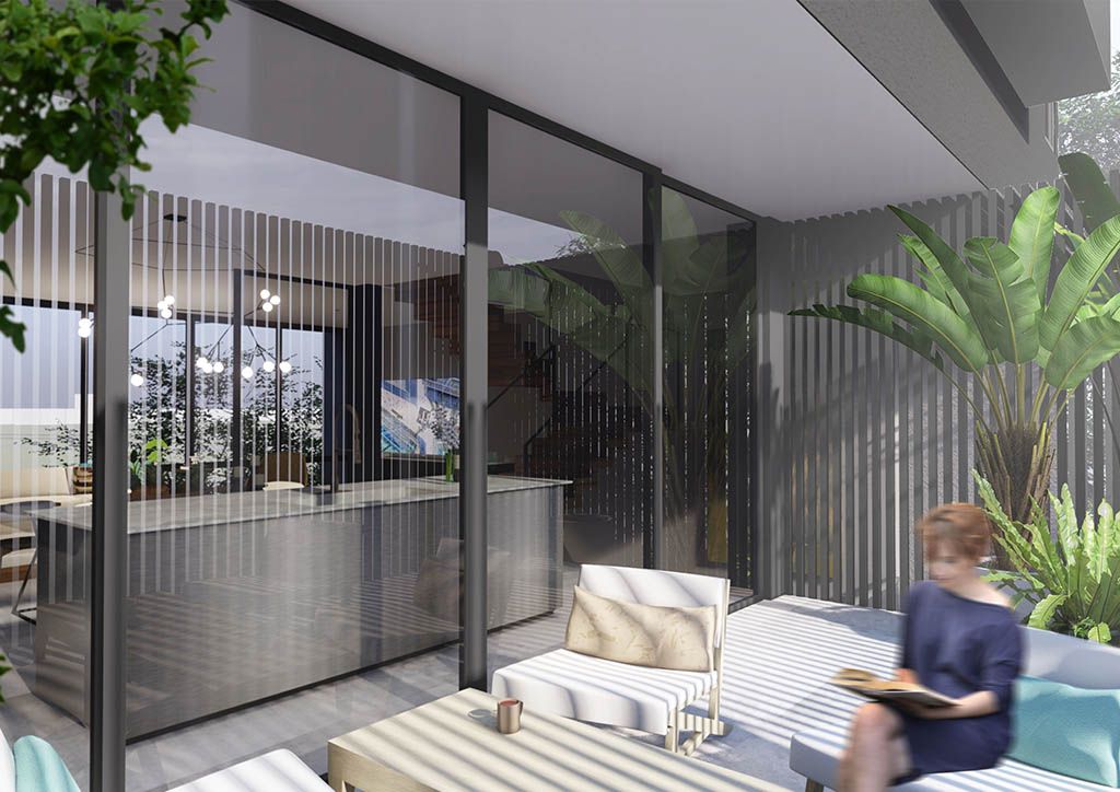A woman sits on the sundeck of modern bahay kubo next to a palm tree and patio furniture.
