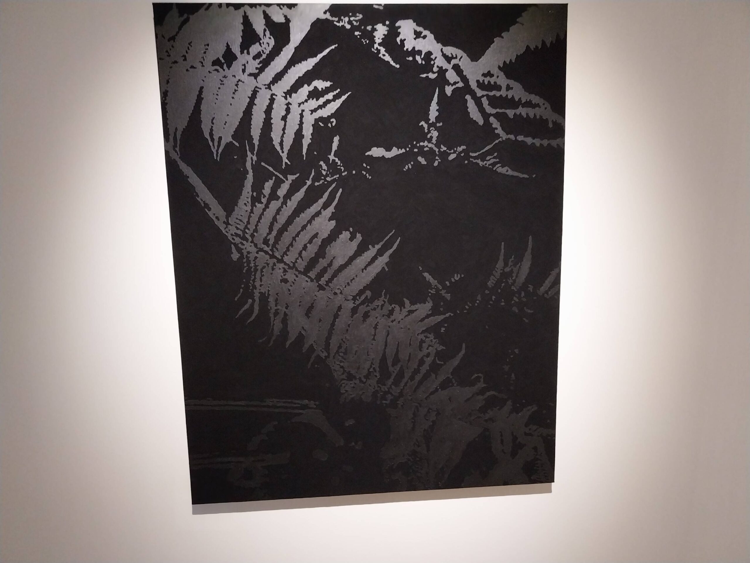 What appears to be palm leaves in a dark background. Photo by Elle Yap.