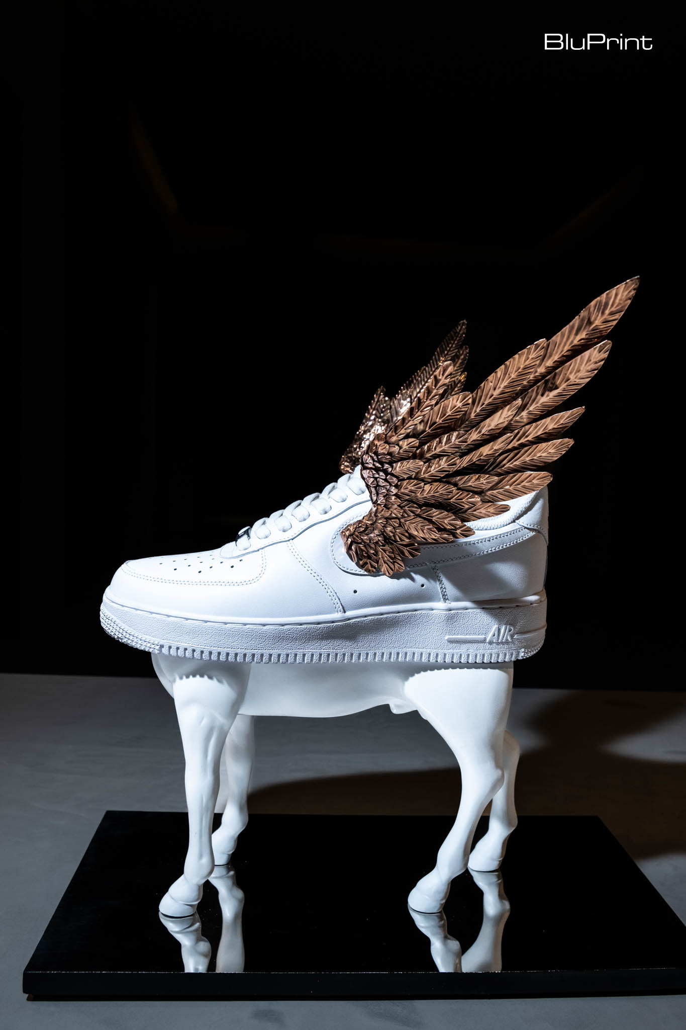A pair of white sneakers with gold wings designed by Daniel dela Cruz.