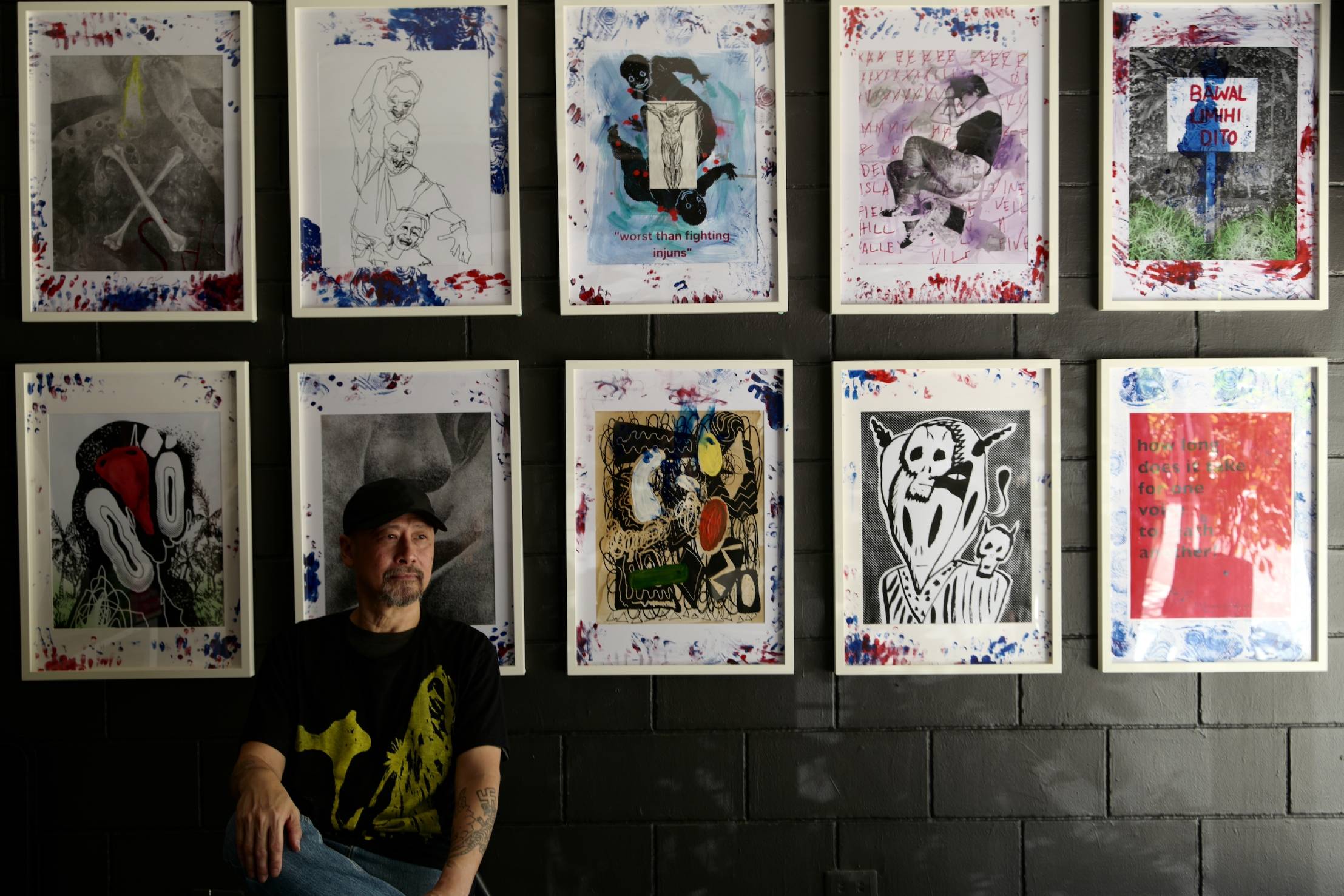 Manuel Ocampo behind some of his works.