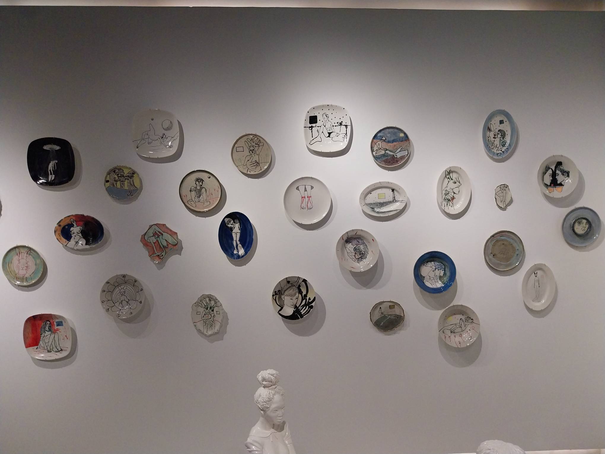Some of the plates positioned above the porcelain sculptures.
