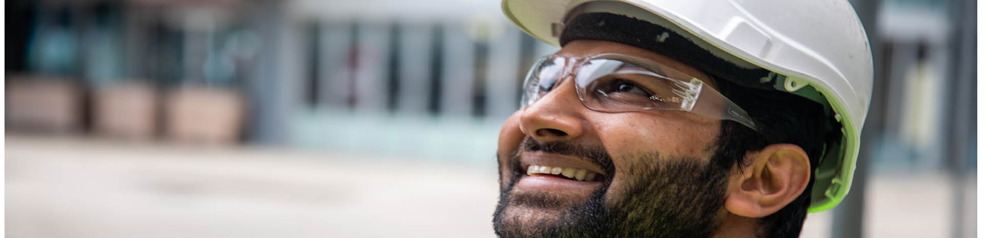 Our Vision Man in hard hat and glasses looking at the sky
