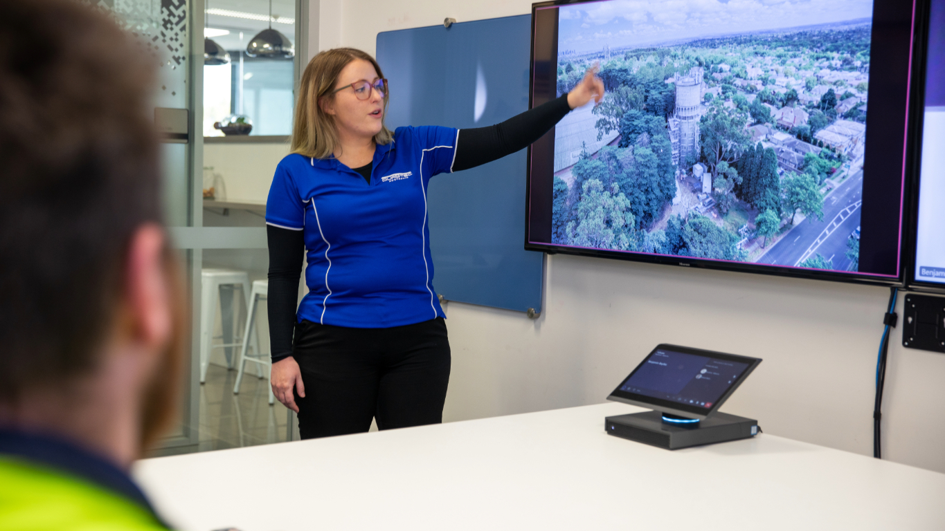 Woman in office pointing at screen Our Vision