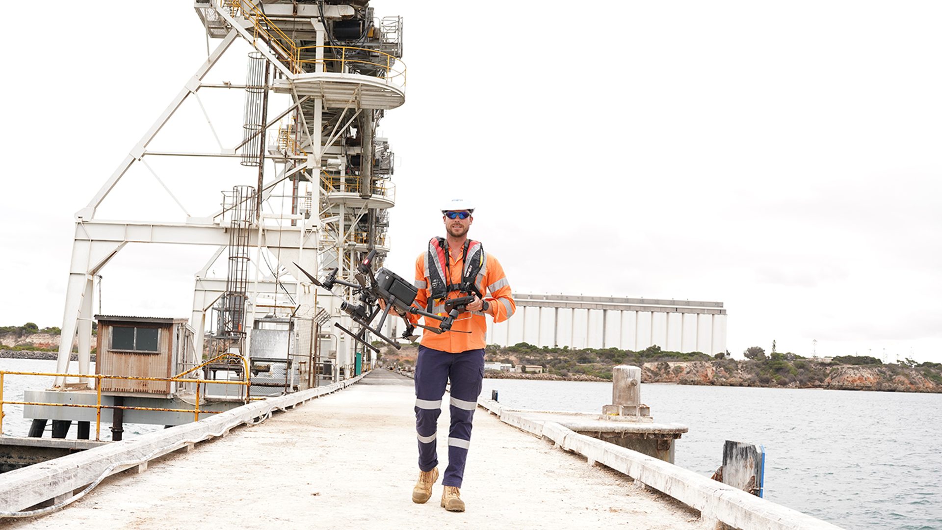 Aden Peterson walking down Flinders Port dock with drone in hand.