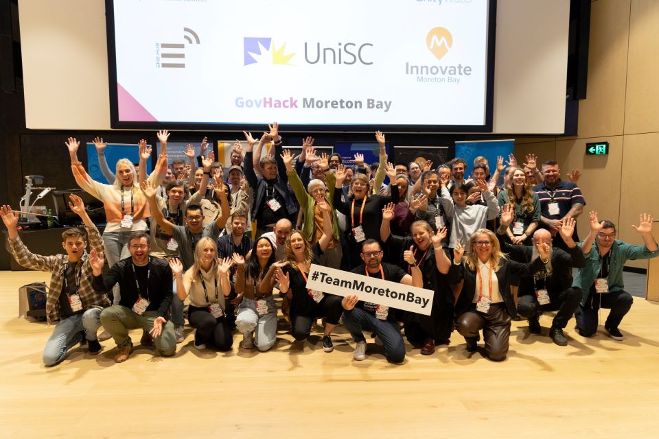 TeamMoretonBay folks taking fun photo in front of screen