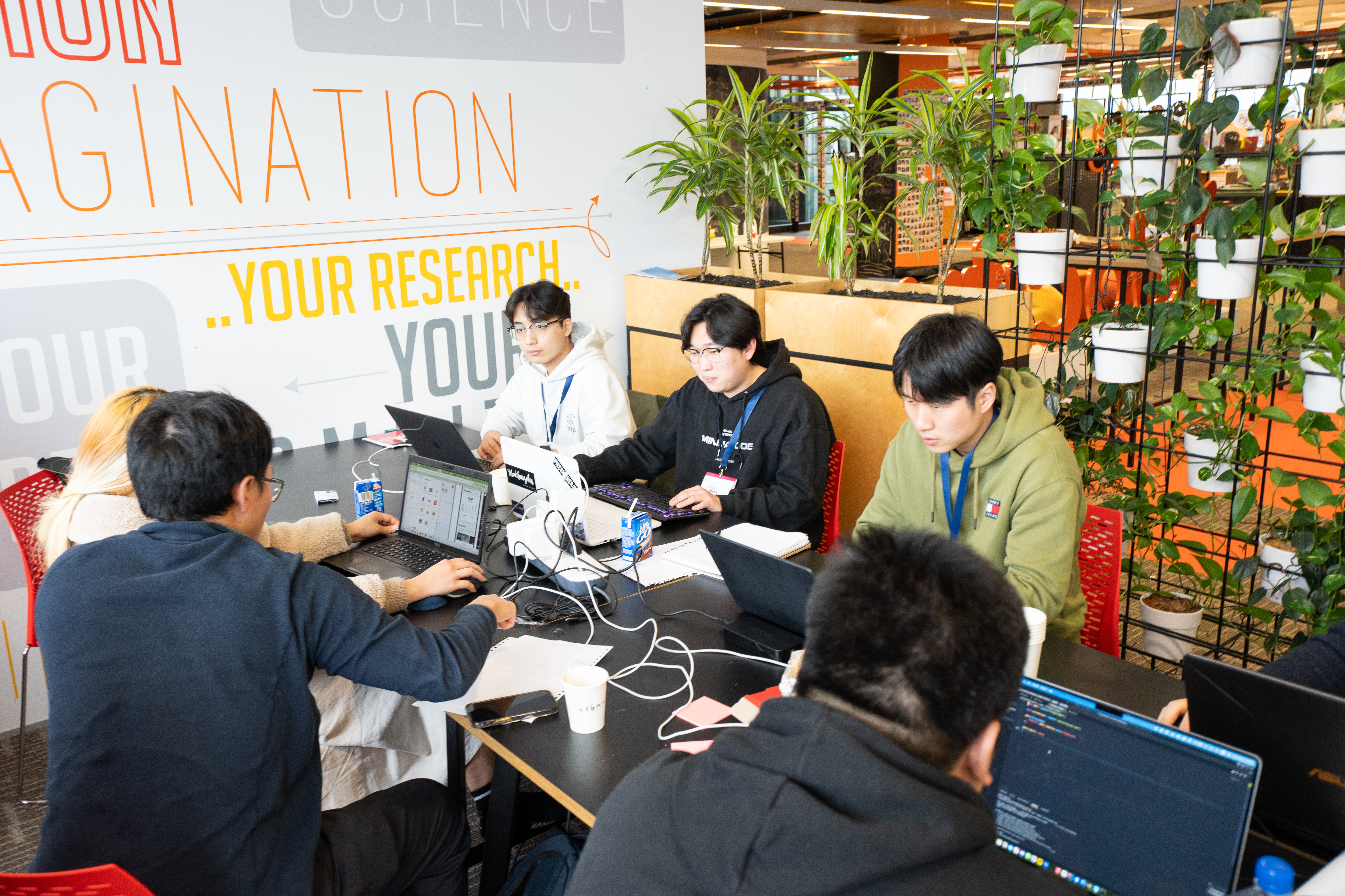 Project team working on laptops around a table in New Zealand