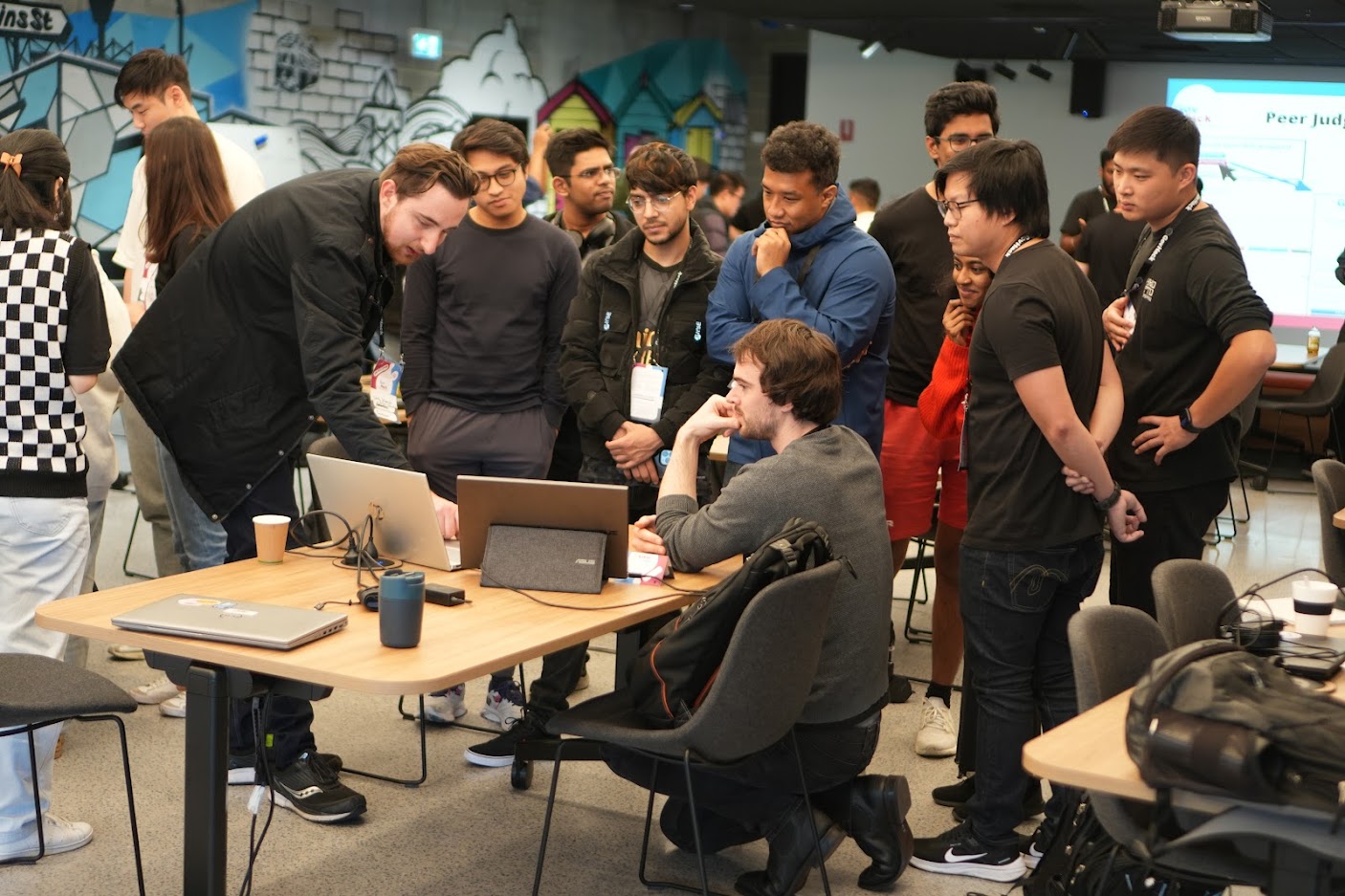 Group of people collected around laptop