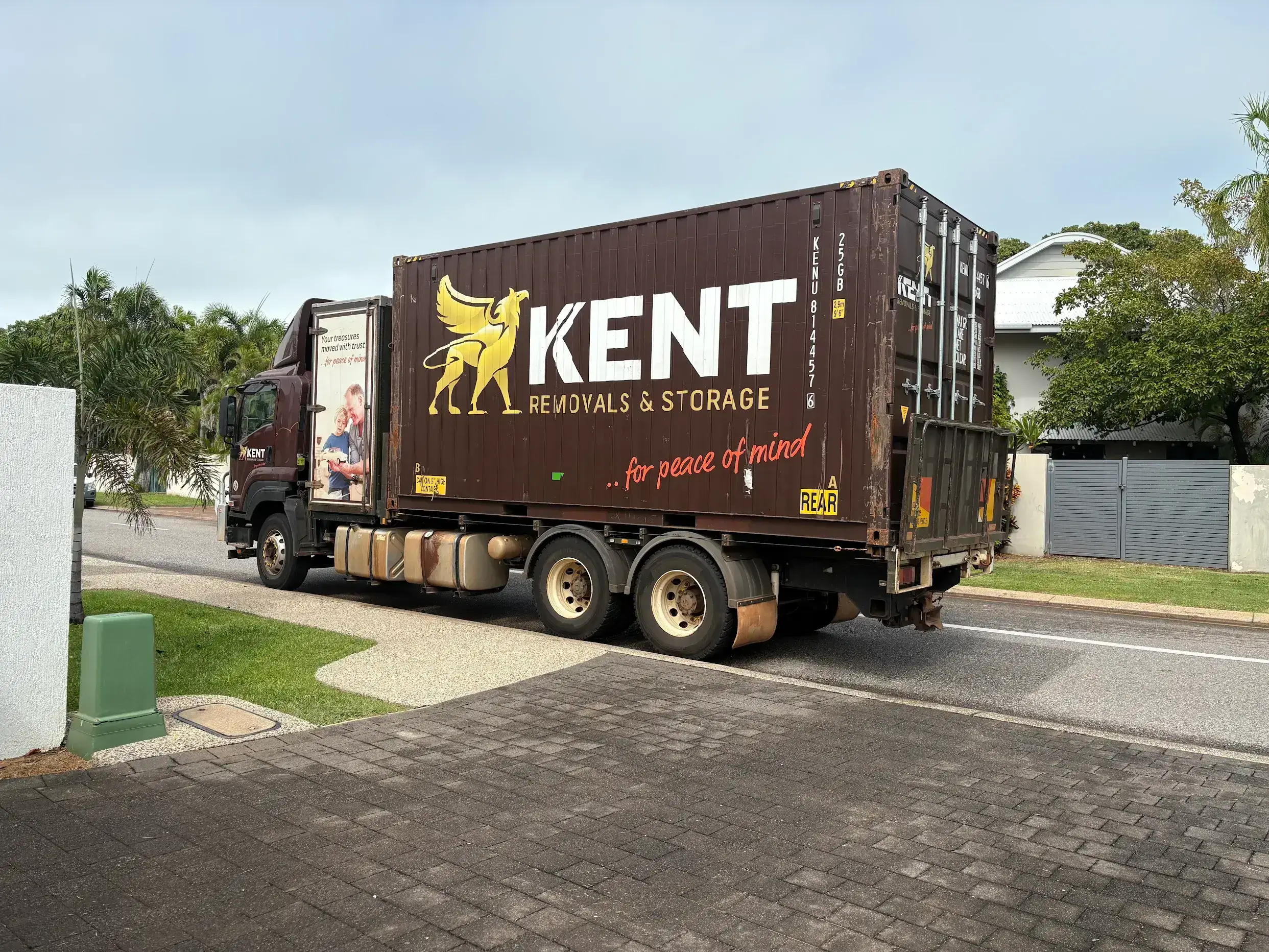 Kent Removals truck transporting storage container through residential street