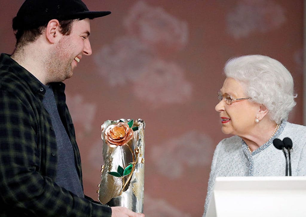 Queen Elizabeth II presenting the award to fashion designer Richard Quinn; IMAGE: Harper's Bazar