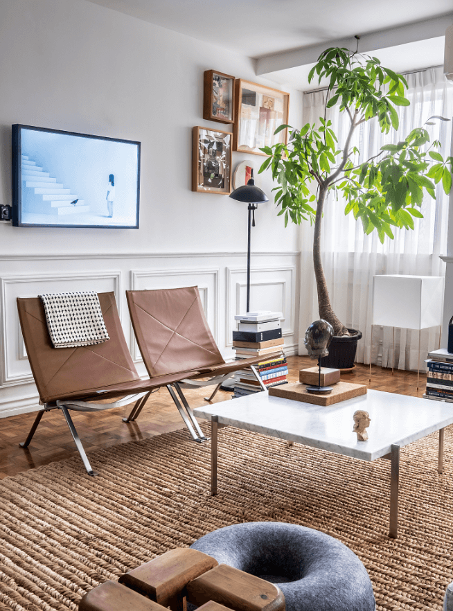 The leather chairs and center table (by Poul Kjærholm for Fritz Hansen) face the HAY Mags sofa; artworks on the wall by (clockwise from left) Mark Aran Reyes, Max Balatbat and Pinky Umarza; head sculpture atop the table by Siegrid Bangyay