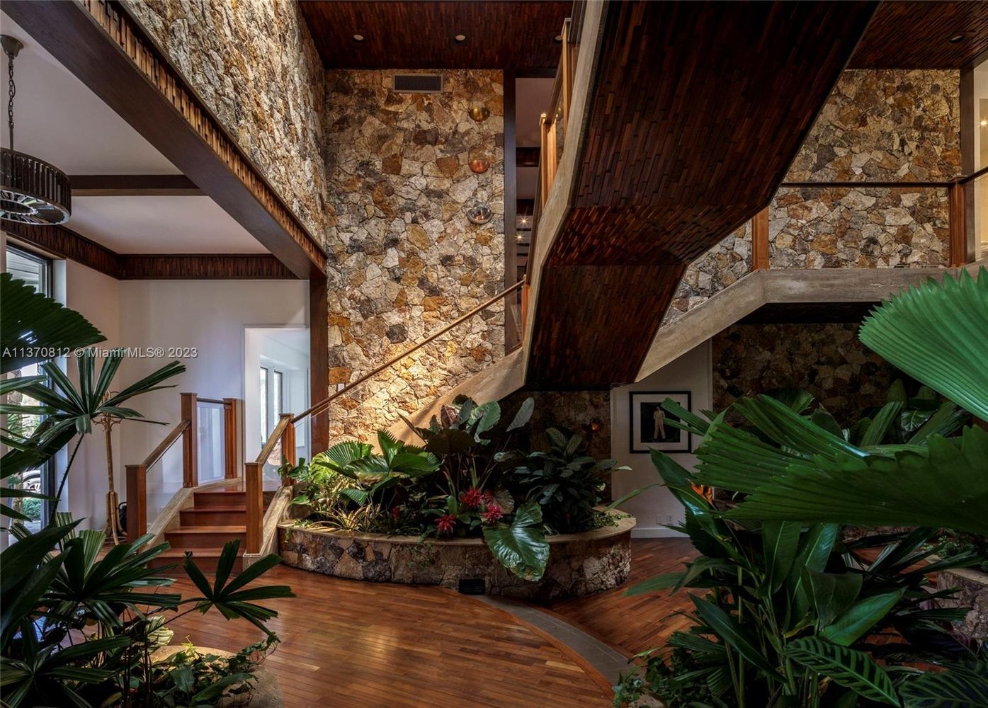 Coral stone walls and plants, as well as a floating staircase, complete the tropical-inspired lobby