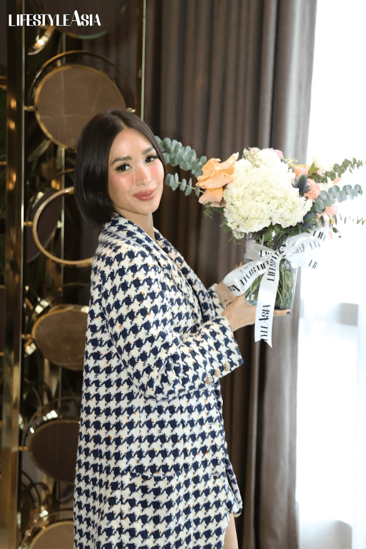 Heart Evangelista holding the flowers she made during the workshop.