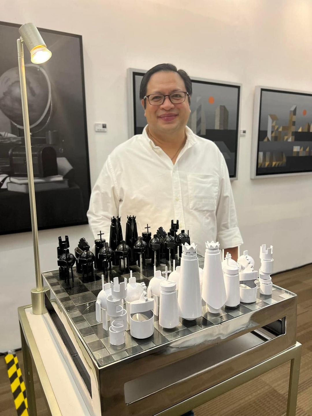 Nixxio Castrillo posing behind a unique chess set he created