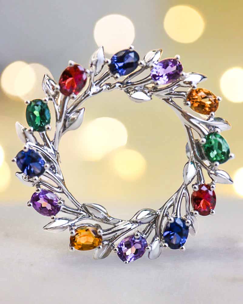 The white gold Wreath Brooch with amethysts, sapphires, emeralds, and rubies
