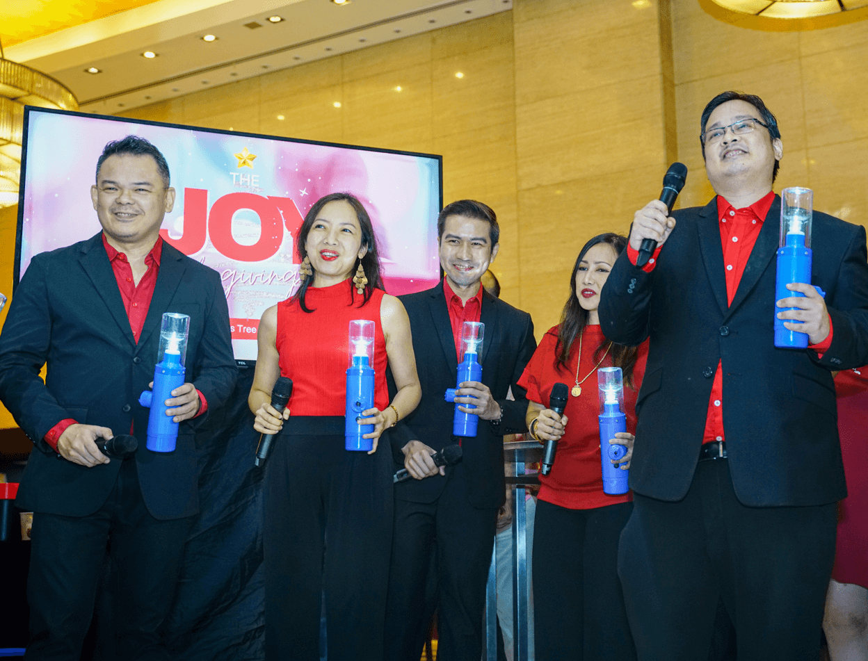 The singers of Antholoy.ph holding the solar lamps of Liter of Light, which Joy~Nostalg donated to a community without electricity for a brighter Christmas celebration