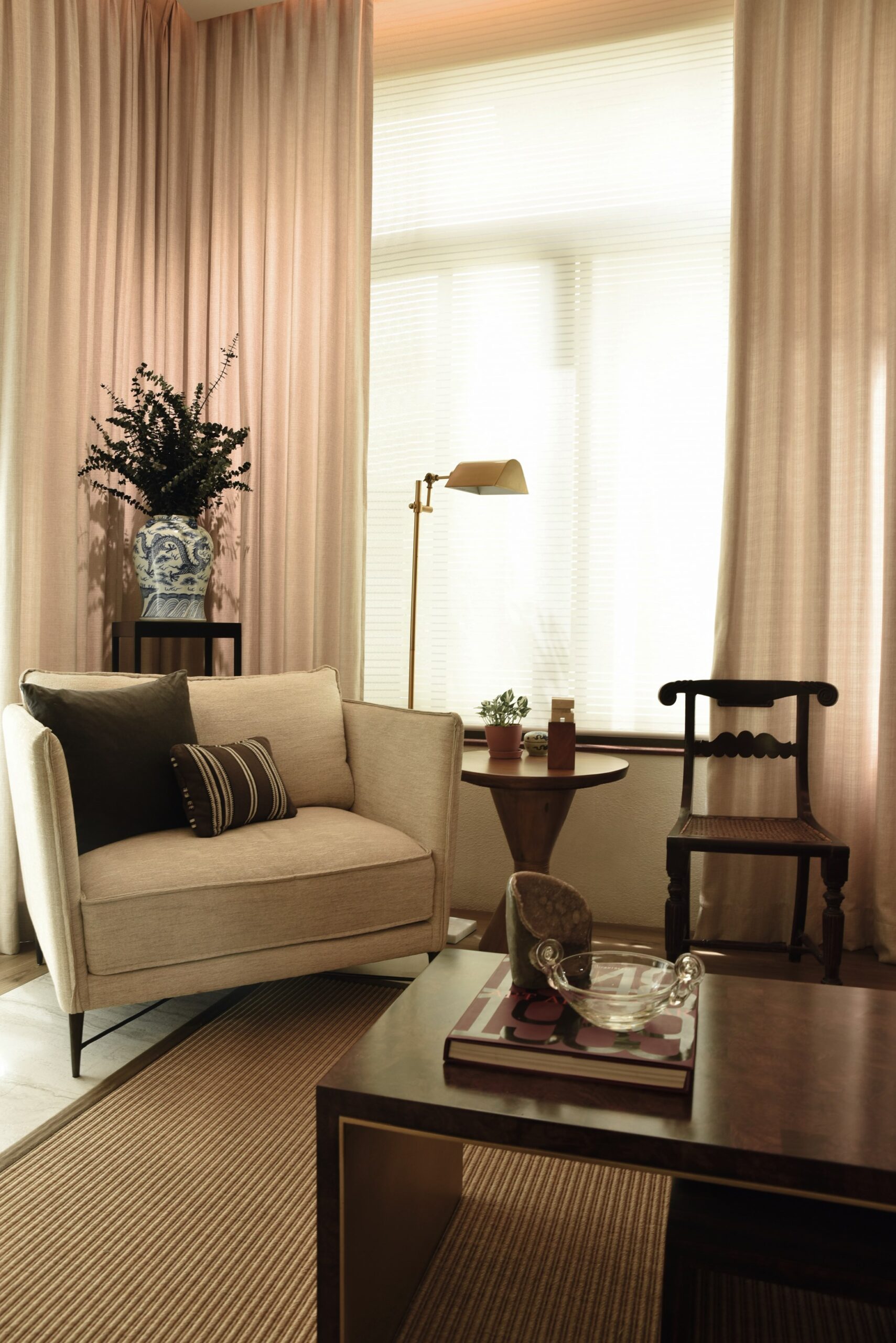 A modern armchair and lusong-form side table from More Than a Chair are set next to a 19th century Bulacan side chair and a Kamagong Manila aparador from the same period. On top of the table is a rare ivory sculpture by Arturo Luz.
