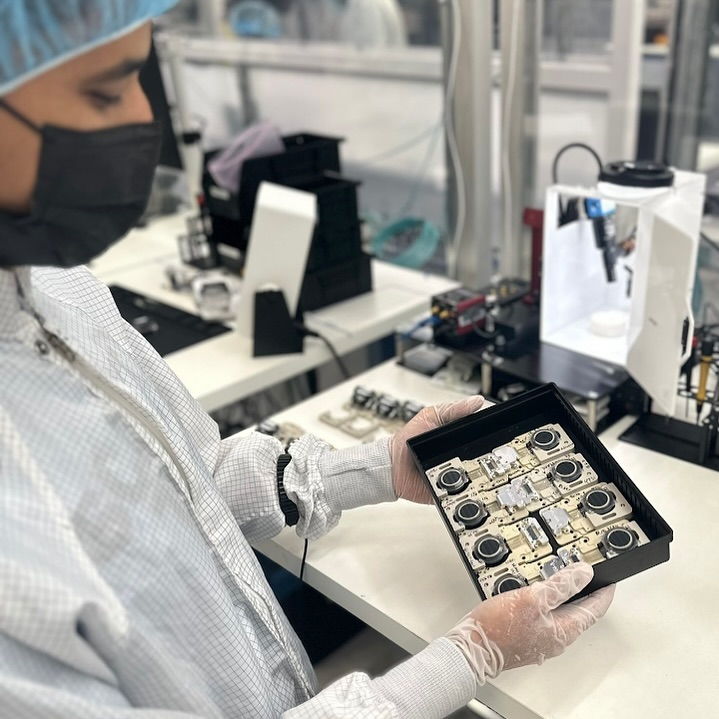 A staff member in Neuralink holding N1 implants