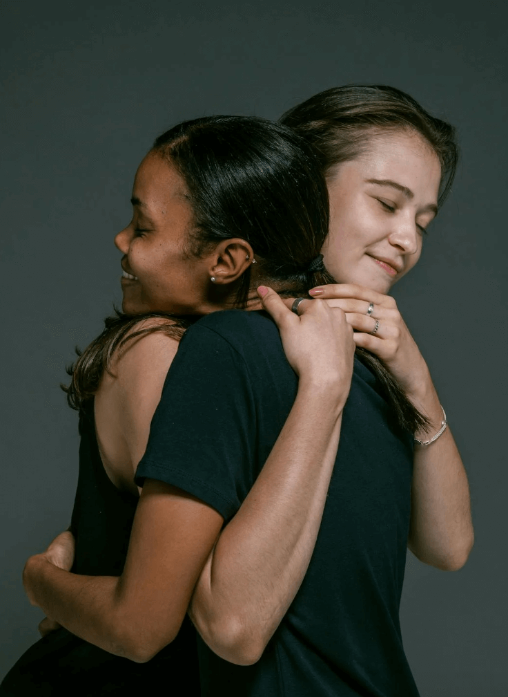 Two happy women hugging each other, forgiving.