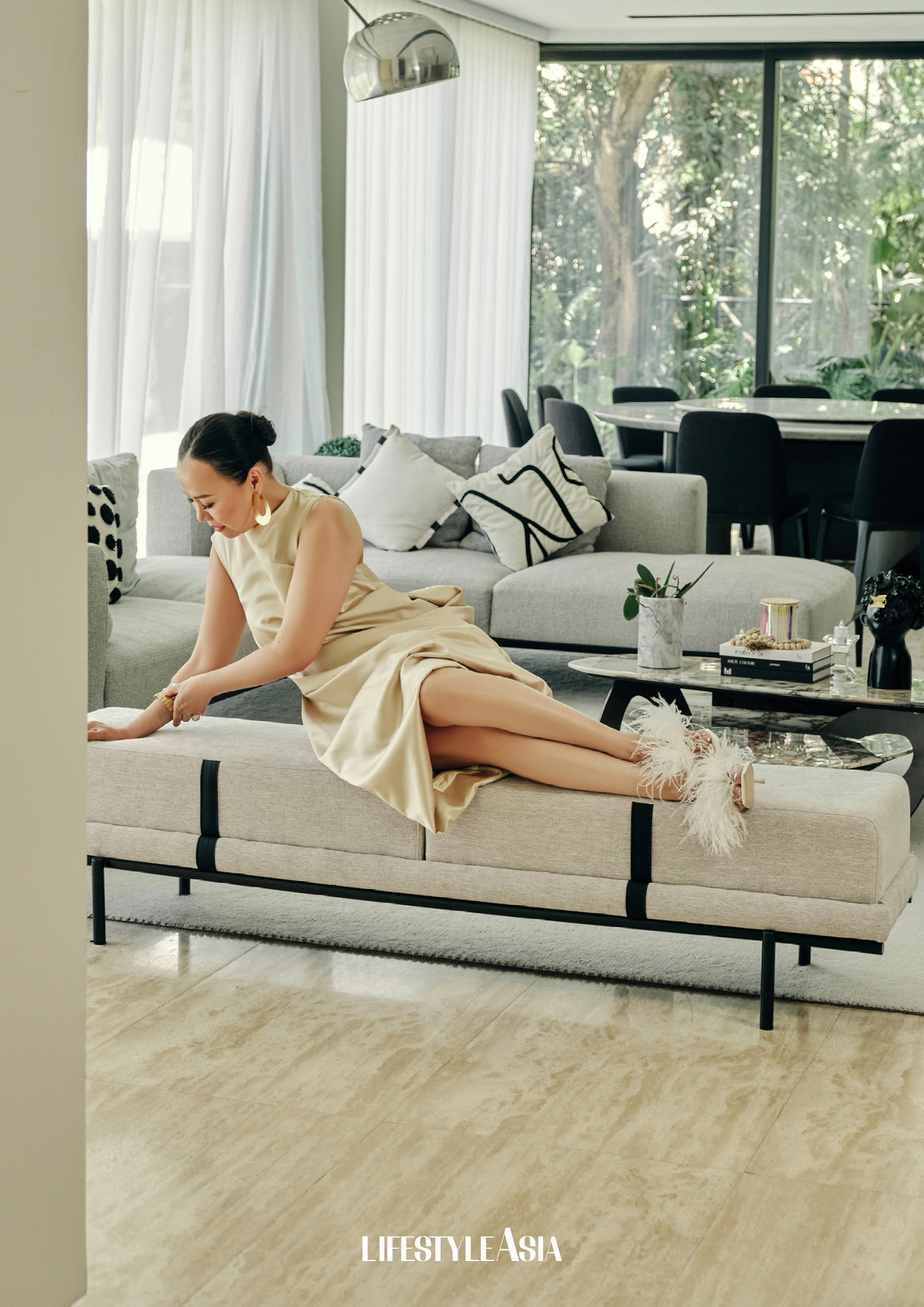 ON BENG: Ecru draped shift dress, MURMEL; Gold earrings and bangle, RIQUEZA; Feathered sandals, CULT GAIA