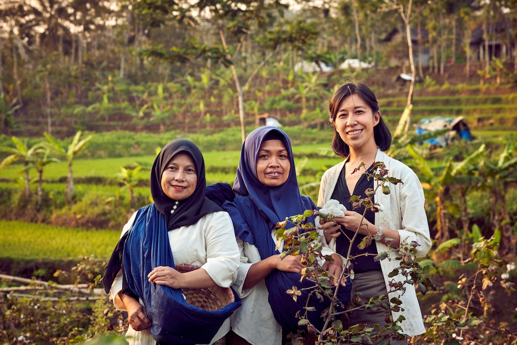 Denica Riadini-Flesch, founder of SukkhaCitta (right) holds cotton harvested on a far near Central Java, Indonesia, by Ibu Tun (left) and Abu Dair (middle). The cotton will be used to create high-quality, traditionally crafted clothes, making SukkhaCitta a true farm-to-closet company. 
©Rolex / Sébastien Agnetti
