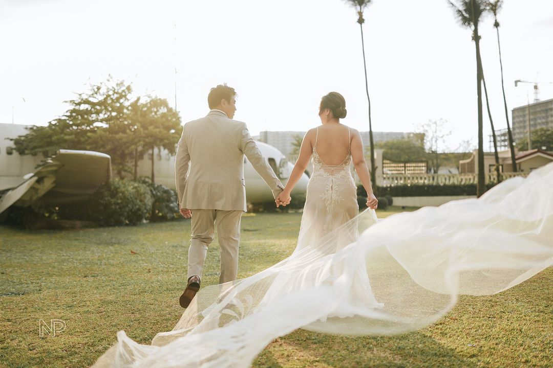  A bride and groom walking hand in hand on the grounds