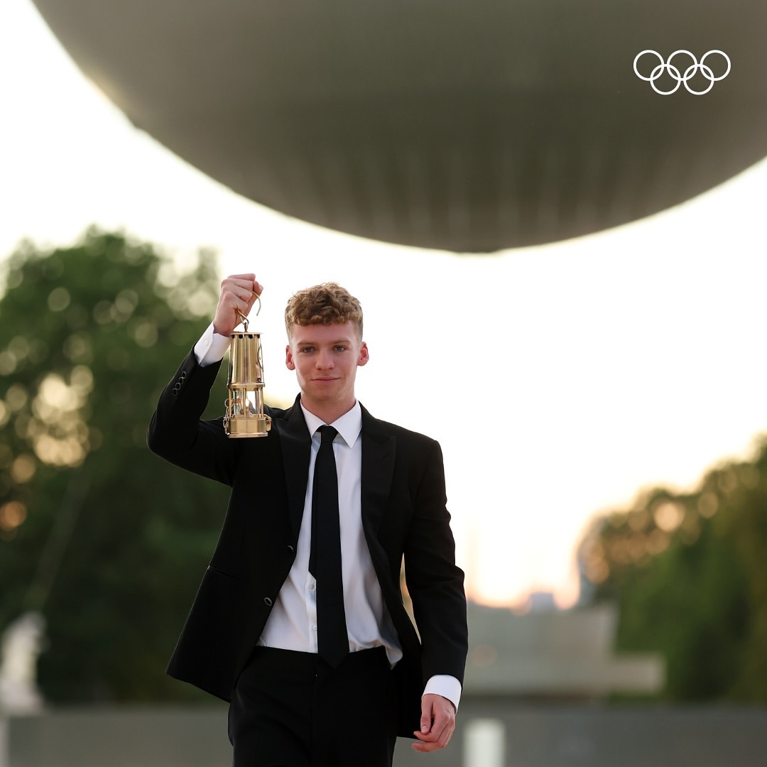 Léon Marchand with the Olympic lantern