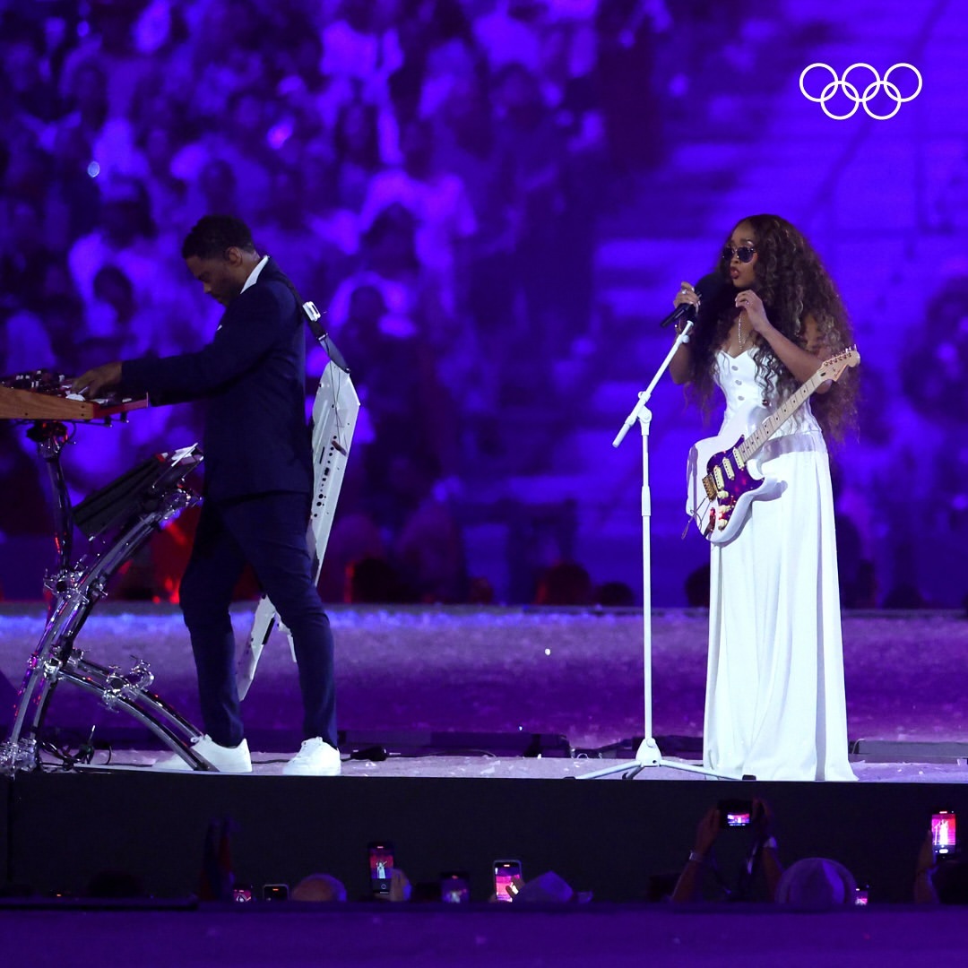 H.E.R. performed a moving rendition of the American national anthem, while gymnast Simone Biles accompanied Mayor Karen Bass to receive the Olympic flag