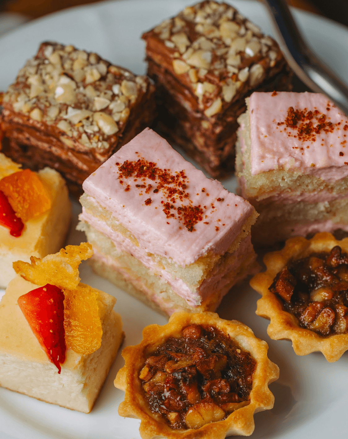 LEFT: Desserts (Mocha Sans Rival, Pecorino Cheesecake with Fresh Strawberries, Strawberry Prosecco tiramisù, and trio of fruit tarts finished with whipped cream). RIGHT: Scones with jam and clotted cream.