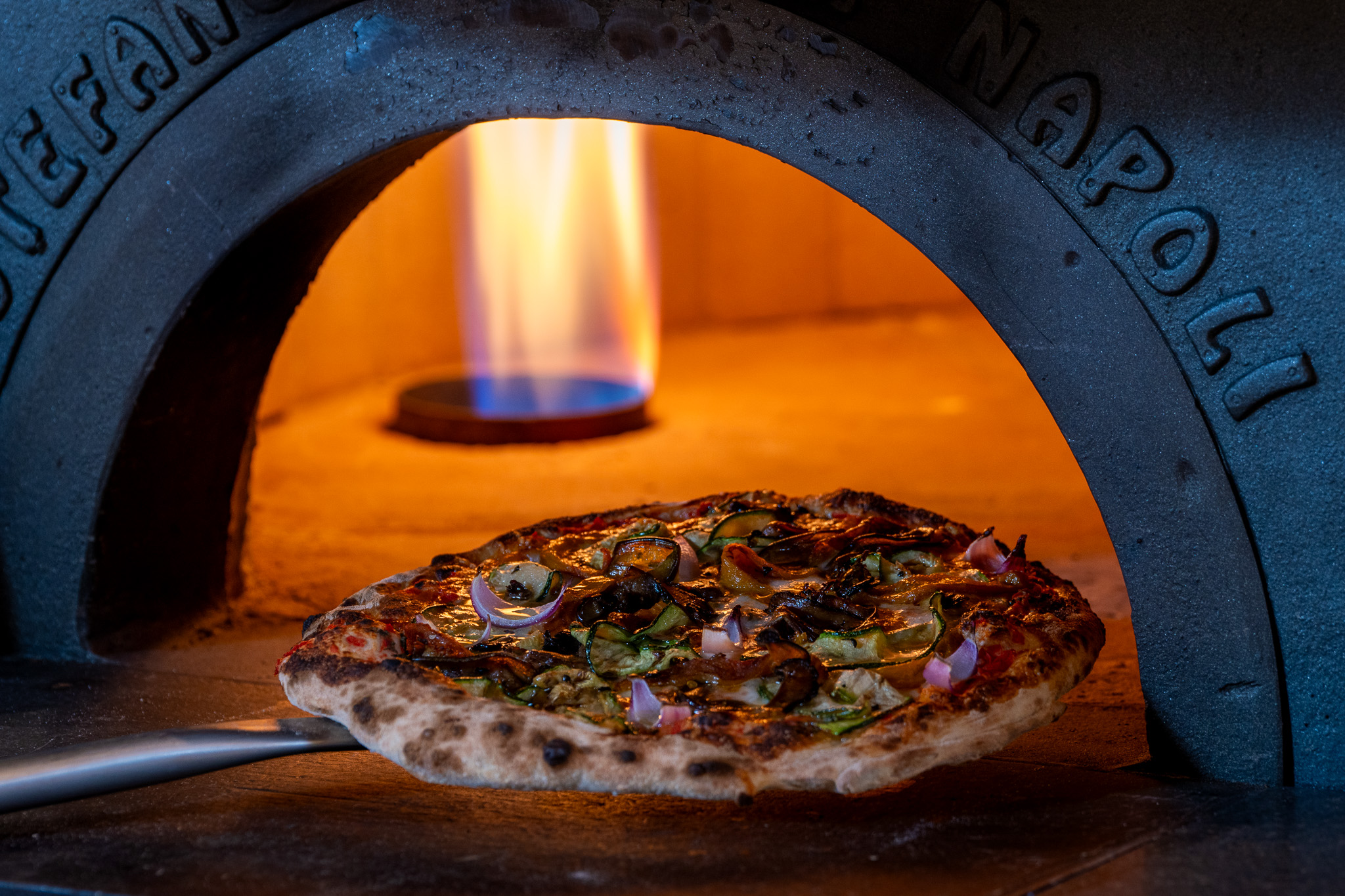 Pizzas and calzoni are made in traditional brick ovens from Naples, Italy