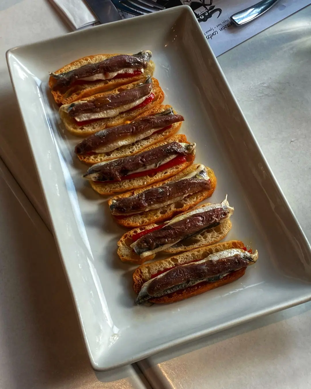 New menu items from Bar Pintxos: Matrimonio (vinegar marinated anchovy served with pepper on toast); Brocheta De Gambas Y Papada (grilled prawn and bacon skewer) July 2025