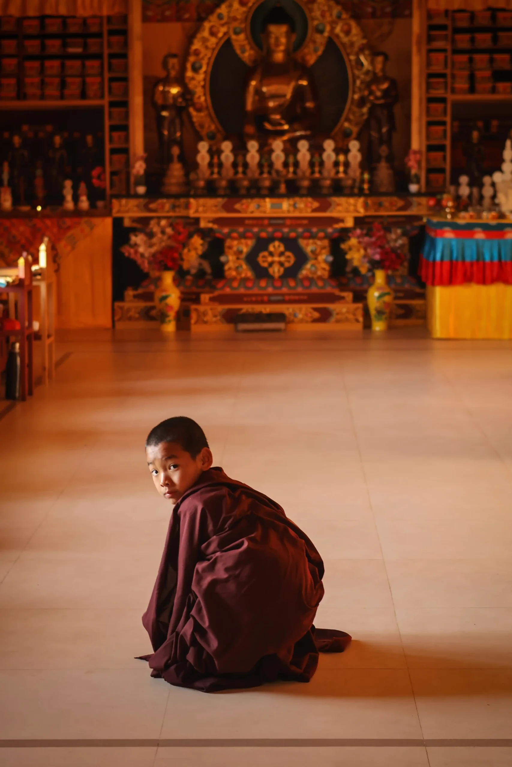 Young monastic student enters the prayer room at Nedo, Sikkim India