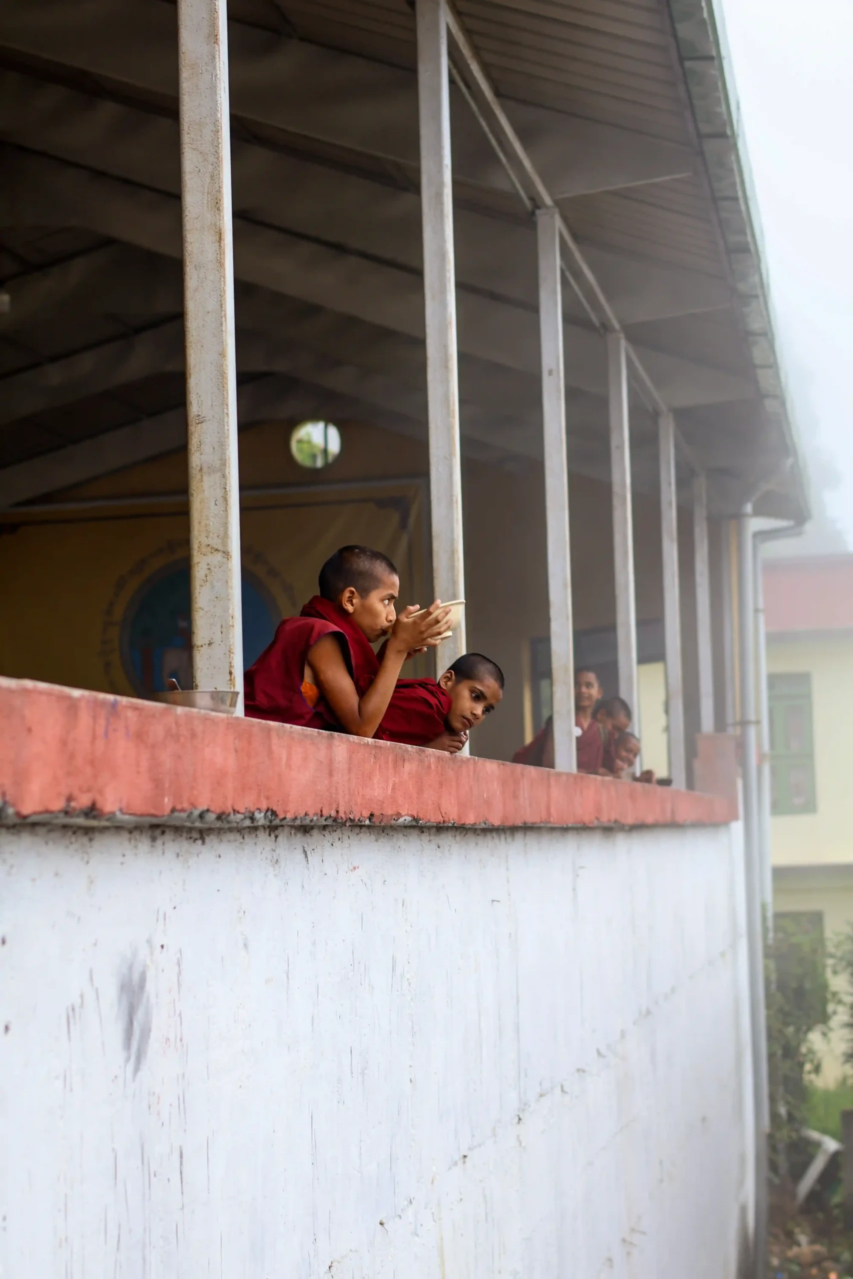 Monastic Students Sipping Tea on a Misty Background Rumtek