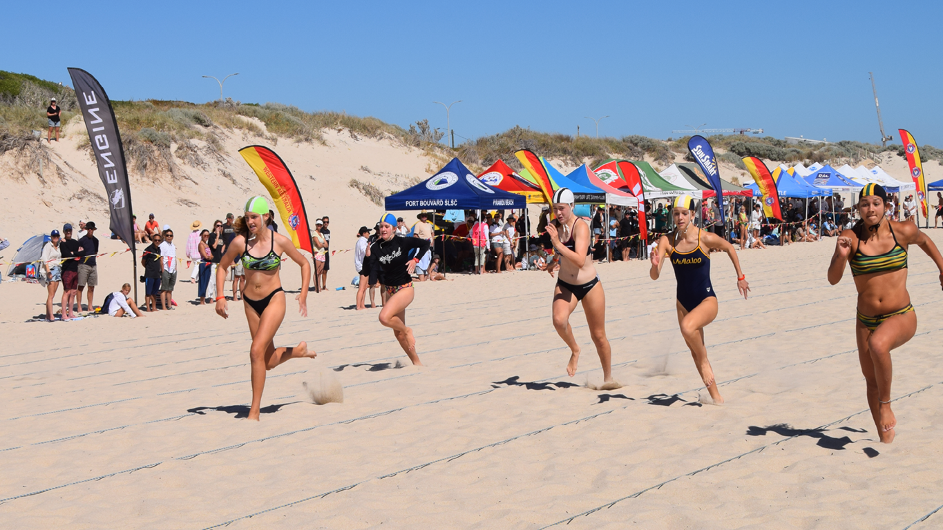 Marquees and competitors at a surf life saving beach carnival