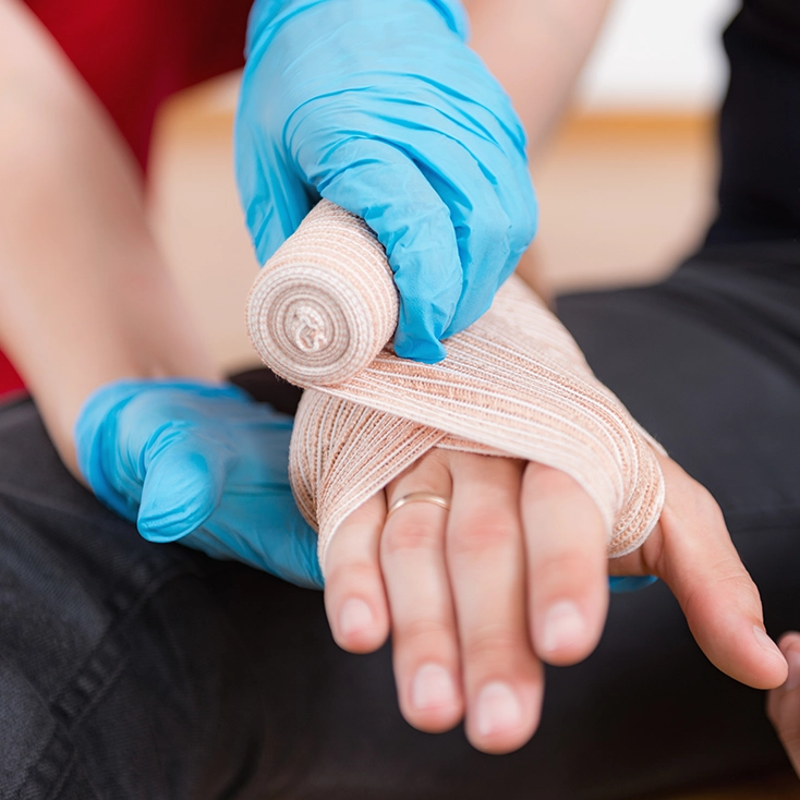Hands applying a bandage during first aid training