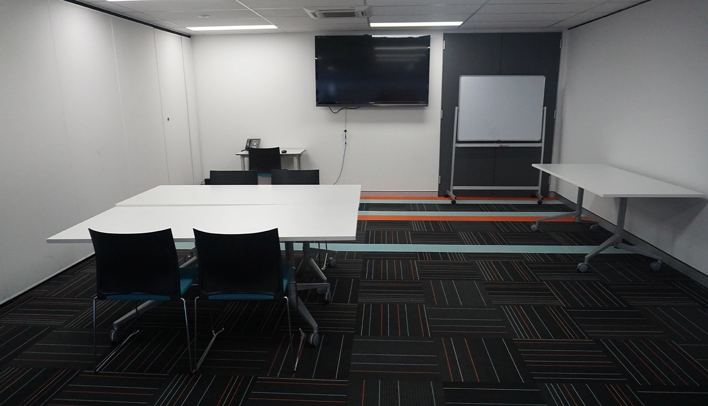A training room with a presentation screen and desks