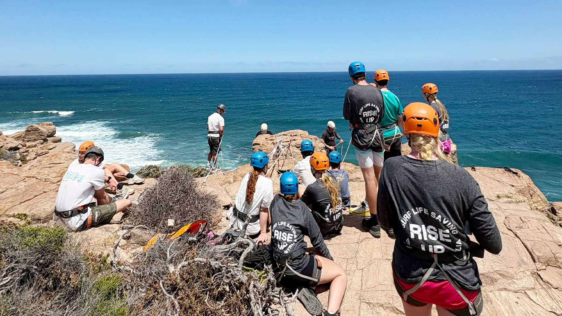 Youth camp participants abseiling on a coastal cliff