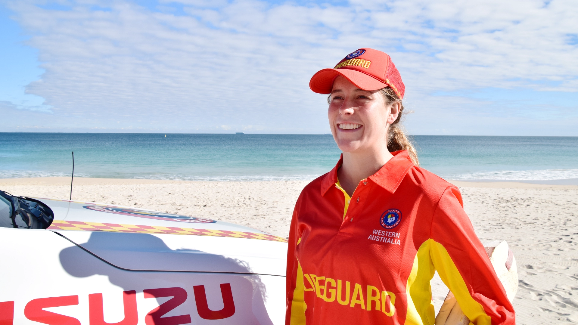 A lifeguard on patrol beside an Isuzu support vehicle