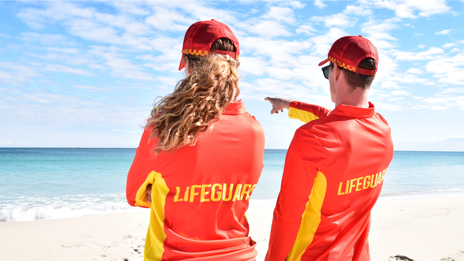 Two lifeguards pointing out to sea while on patrol